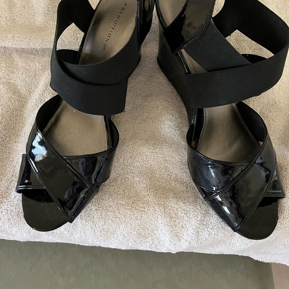 Black patent wedge sandles Wide black elastic crosses at the instep 3 1/2” heel.